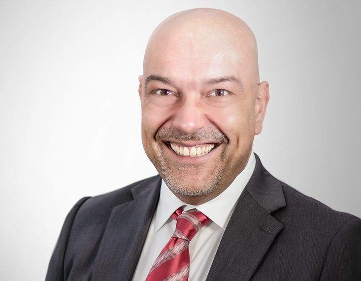 Professionelles Business-Porträt von Torsten Gatz in Anzug und Krawatte mit freundlichem Gesichtsausdruck vor hellem Studiohintergrund.