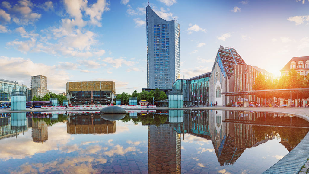 Blick auf den Leipziger Augustusplatz mit Universitätsgebäuden, Gewandhaus und Hochhaus im Abendlicht.
