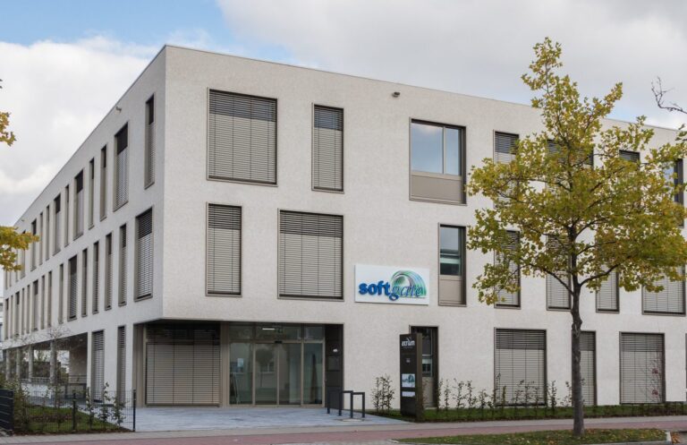Modernes Bürogebäude mit mehreren Fenstern und einem softgate-Firmenschild an der Fassade.